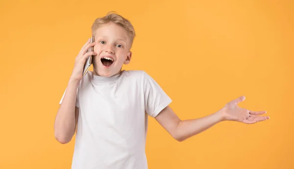 Podekscytowany chłopak rozmawiający przez telefon i gestykulujący — Zdjęcie stockowe