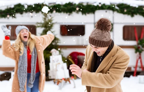 Lotta con le palle di neve. Coppia romantica divertirsi all'aperto, gettando neve a vicenda — Foto Stock