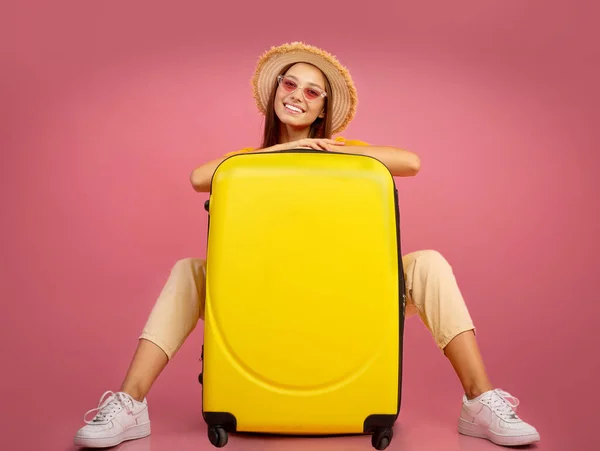 Hezká dívka v letním klobouku a sluneční brýle pózování s kufrem — Stock fotografie