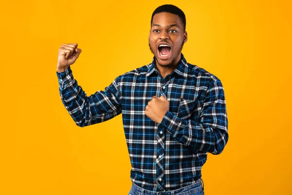 Schwarzer Kerl schreit laut gegen seine Brust und posiert im Studio — Stockfoto