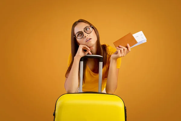 Giovane donna confusa con occhiali da sole in possesso di passaporto e biglietti — Foto Stock