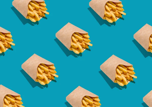 Muitas batatas fritas em caixas de papel sobre fundo azul, repita o padrão — Fotografia de Stock