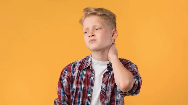 Portret van een vermoeide schooljongen die de nek aanraakt, pijn voelt — Stockfoto