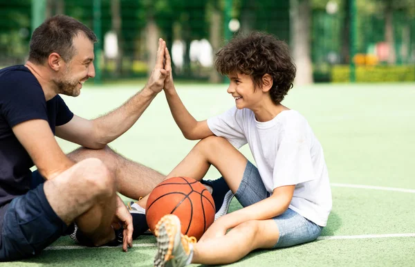 Portrait of dad and son giving high five playing basketball — Stock Photo, Image