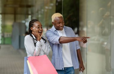 İnsanlar, satış ve mutluluk ifadesi. Şok olmuş çift bakıyor ve parmağıyla vitrini işaret ediyor