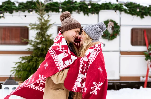 Romanticismo invernale. Amare giovane coppia coccole sotto coperta calda al campeggio — Foto Stock