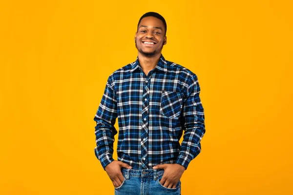 African Guy Posing Holding Hands In Pockets Over Yellow Background — Stock Photo, Image