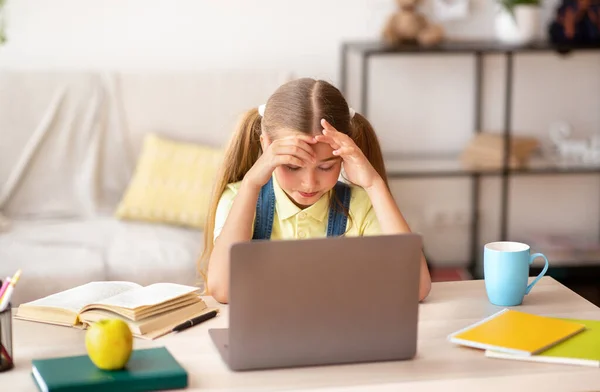 Chica de la escuela cansada con dolor de cabeza usando PC —  Fotos de Stock