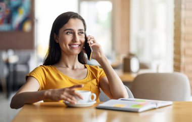 Gülümseyen güzel kız telefonda konuşuyor.