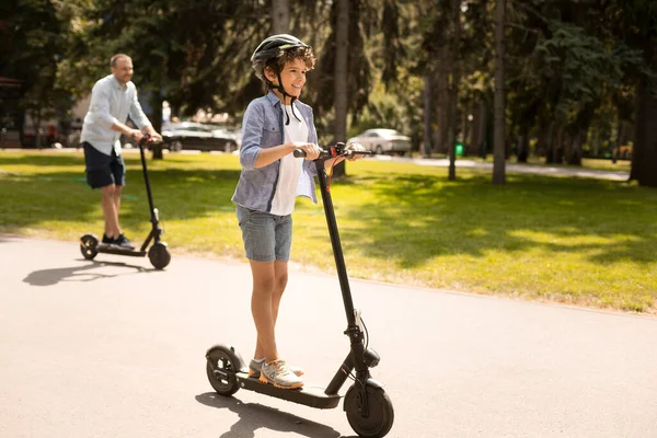 Feliz chico con papá teniendo paseo en scooter de patada eléctrica — Foto de Stock