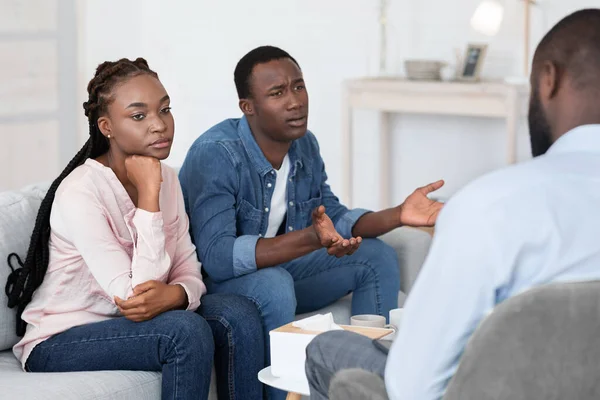 Homem africano emocional reclamando de problemas com a esposa na sessão de terapia de casal — Fotografia de Stock