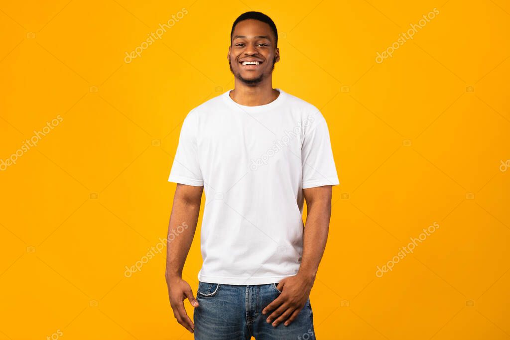 Black Man Smiling To Camera Posing, Yellow Background, Studio Shot