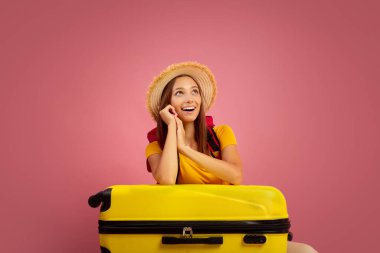 Heyecanlı kız çantalı pembe arkaplandaki kopyalama alanına bakıyor