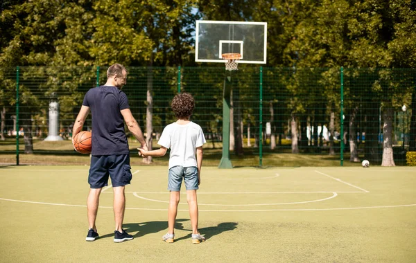 Άνθρωπος που ποζάρει με τον γιο του στο γήπεδο μπάσκετ — Φωτογραφία Αρχείου