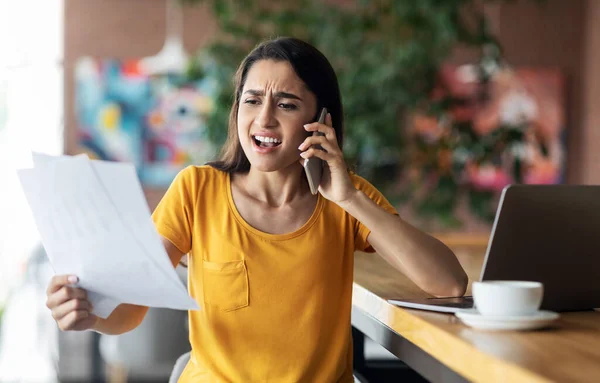 Furioso árabe menina ter conversa no telefone, segurando documentos — Fotografia de Stock