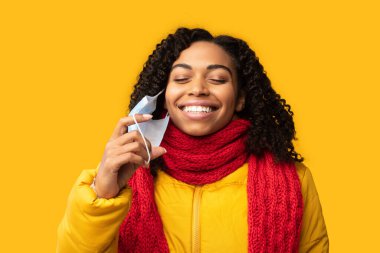 Neşeli Afrikalı Kadın Sarı Arkaplanda Tıbbi Maskeyi Çıkartıyor