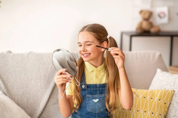 Ung flicka gör makeup, Tillämpa Mascara, Innehavs spegel — Stockfoto