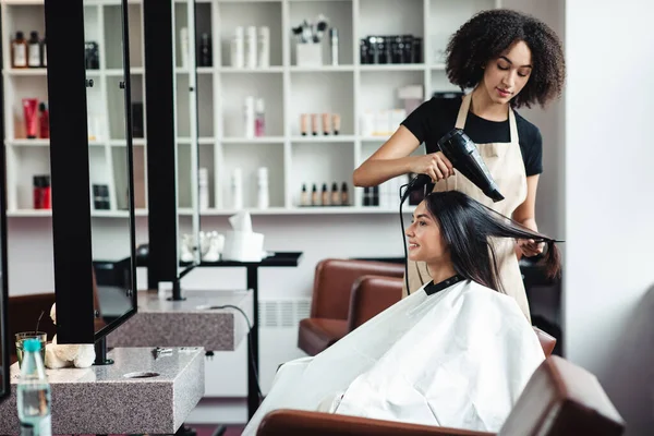 Jovem morena desfrutando de penteado profissional no salão de beleza — Fotografia de Stock