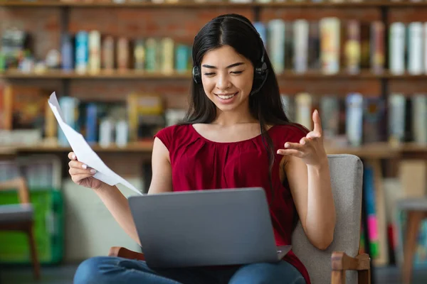 Fjärrkontroll. Leende asiatisk kvinna pratar med affärspartners via online-konferens — Stockfoto