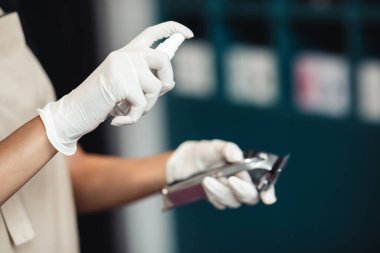 Elektrikli budama makinesine dezenfektan sıkan usta elleri kapat.