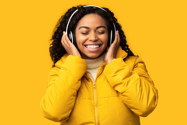 Afrikaans meisje luisteren lied genietend geluid in hoofdtelefoon in studio — Stockfoto