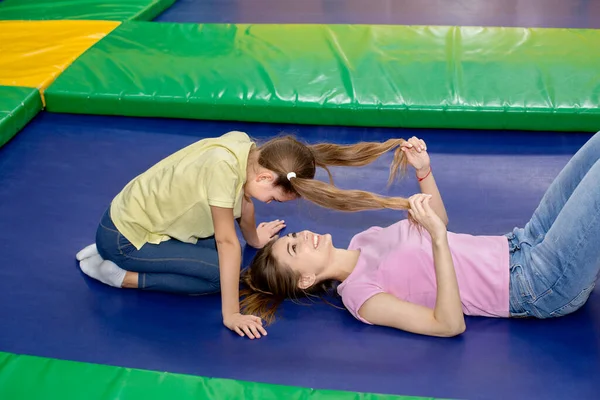 Family recreation ideas. Happy mother having great time with her daughter at indoor trampoline park