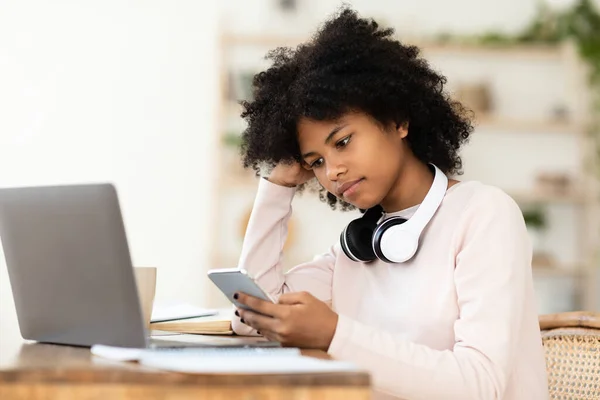 Akıllı Telefon Kullanan Afrikalı Kız ve Evde Dizüstü bilgisayar İzleme Dersi — Stok fotoğraf