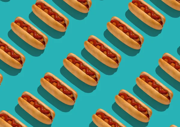 Finom hot dogok kolbásszal és ketchuppal türkiz háttéren — Stock Fotó