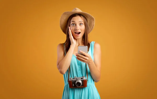 Viaggiatore scioccato ragazza con smartphone su giallo — Foto Stock