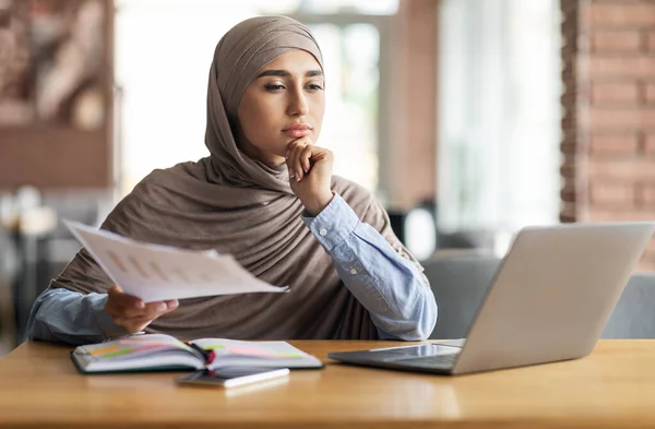 Düşünceli Müslüman kadın yönetici kafede otururken çalışıyor. — Stok fotoğraf