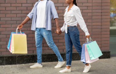 Hafta sonları alışveriş merkezinde alışveriş yapmak. Çok renkli çantaları olan Afrikalı Amerikalı çift.