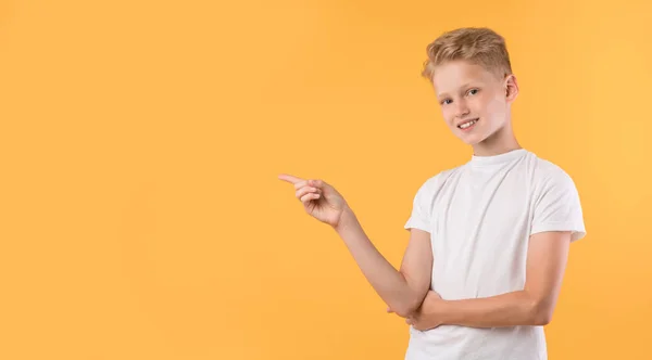 Glücklicher Junge zeigt mit dem Finger zur Seite auf Kopierraum — Stockfoto