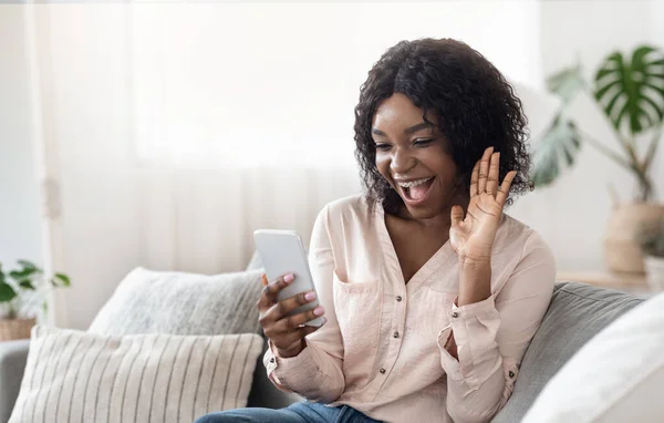 Gioioso africano donna avendo video chiamata con gli amici tramite smartphone a casa — Foto Stock