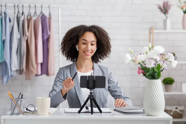 Glimlachen Afrikaans amerikaanse vrouw op zoek naar webcam in woonkamer en streaming video — Stockfoto