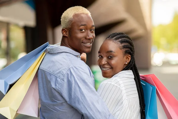 Winkelen, mode en leuke tijd. Portret van een Afrikaans Amerikaans mooi paar met gekleurde boodschappentassen — Stockfoto