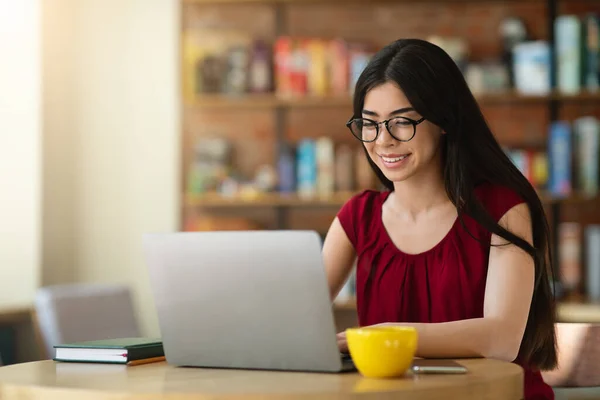 Lächelnd asiatisch student mädchen vorbereitung prüfung mit laptop im cafe, studium online — Stockfoto