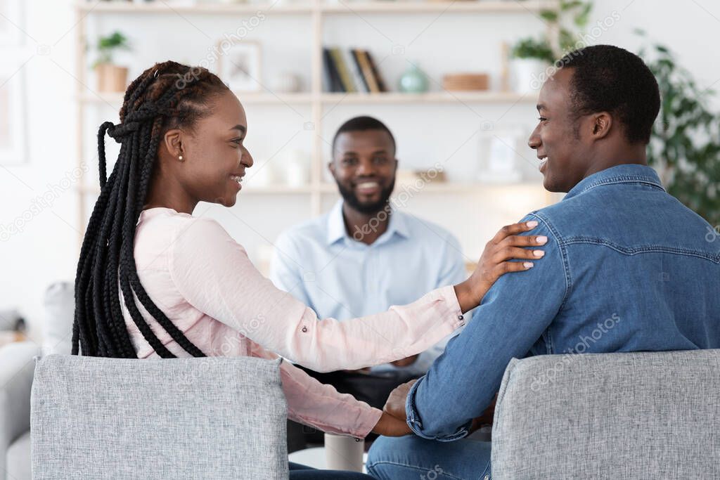 Happy Loving Black Spouses Bonding At Marriage Counselors Office After Successful Therapy