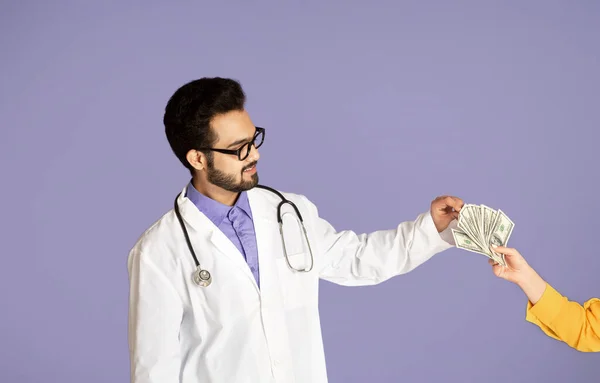 Корупція в концепції сектора охорони здоров'я. Індійський лікар, який бере гроші від пацієнтки через фіолетове походження — стокове фото