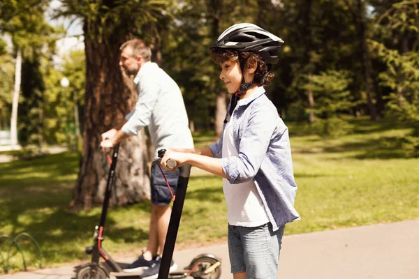 Happy guy with his daddy having ride on e-scooter — Stock Photo, Image