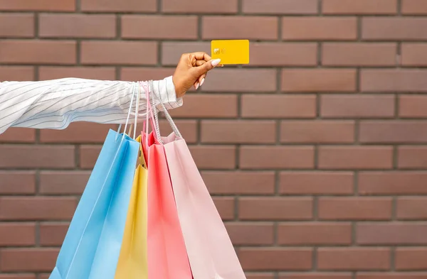 Nowoczesna płatność za zakupy. Kobieta z torbami na zakupy daje kartę kredytową sprzedawcy — Zdjęcie stockowe