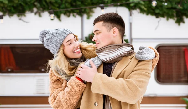 Liebevolles junges Paar, das sich im Winter im Freien umarmt und den Valentinstag auf dem Campingplatz feiert — Stockfoto