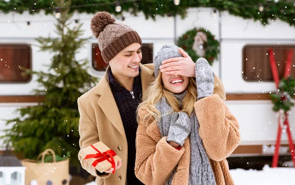Milující přítel překvapující přítelkyně s přítomností během zimního rande na sněžný den — Stock fotografie