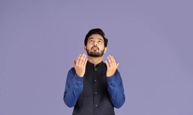 Dindar Hintli adam Tanrı 'ya dua ediyor, menekşe arka planda kefaret istiyor.