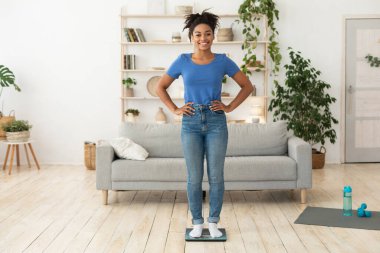 Memlekette zayıfladıktan sonra tartıya çıkan neşeli siyahi kadın.