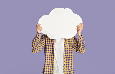 Günlük kıyafetli genç adam yüzünü konuşma baloncuğuyla kapatıyor. Leylak arkaplanı, tasarım için yer.