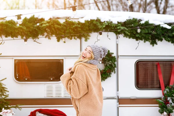 शीतकालीन खुशी। सुंदर सुनहरे बालों वाली लड़की लकड़ी में शिविर पर आरवी के पास पोज़िंग — स्टॉक फ़ोटो, इमेज
