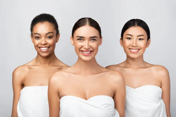 Three Happy Girls Wrapped In Towels Standing On Gray Background — Stock Photo, Image