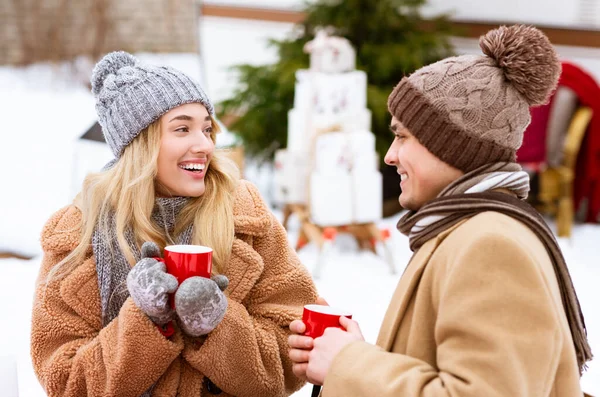 Dos amantes de beber té caliente de tazas rojas durante el invierno Fecha al aire libre —  Fotos de Stock