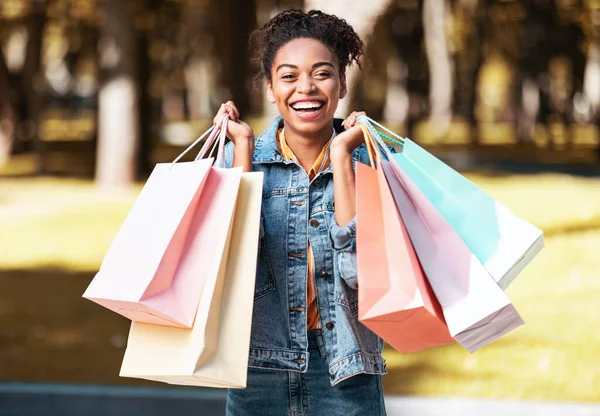 Glad svart flicka efter shopping innehav Shopper väskor står utanför — Stockfoto