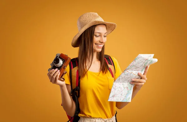 Šťastná dívka cestovatel s kamerou při pohledu na mapu — Stock fotografie